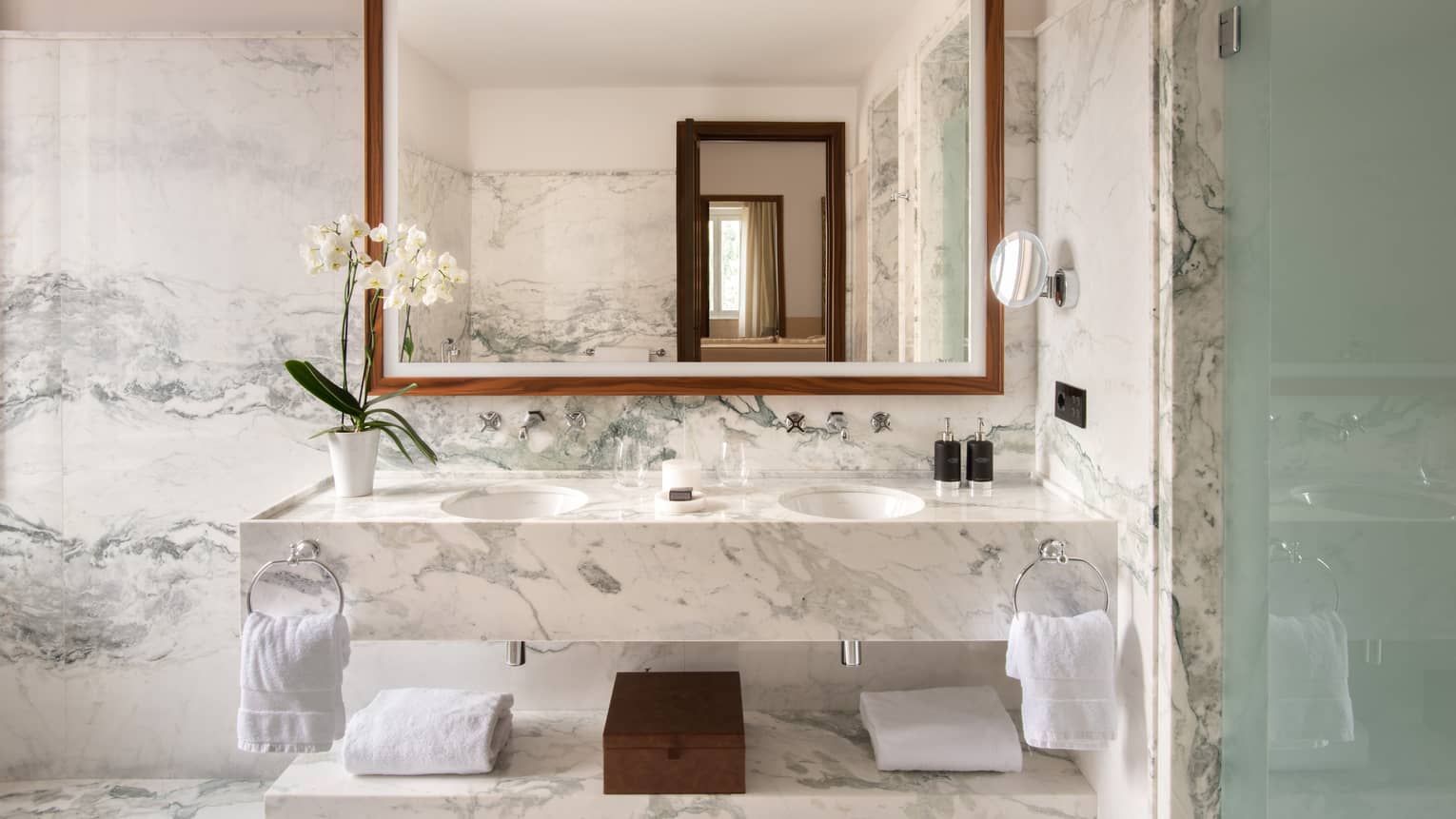 Bathroom with marble vanity, walls and floor, large mirror, two sinks