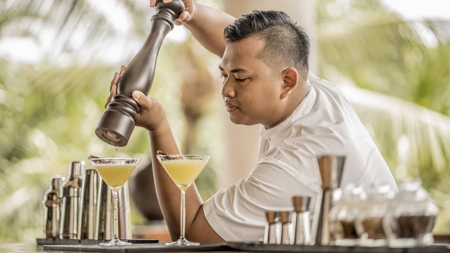 A bartender garnishing a drink with spices in Bali