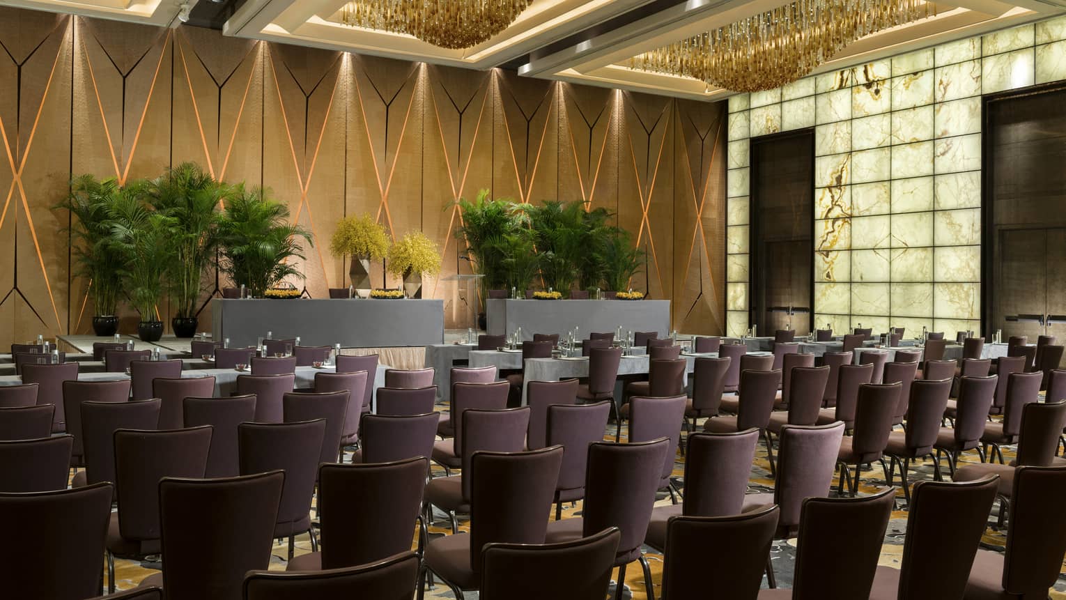 Pearl Ballroom conference with rows of meeting tables facing podium with potted trees 