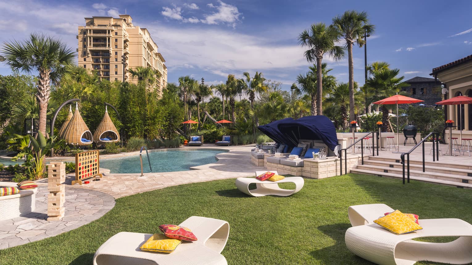 White patio chairs, hanging baskets, palm trees around swimming pool deck