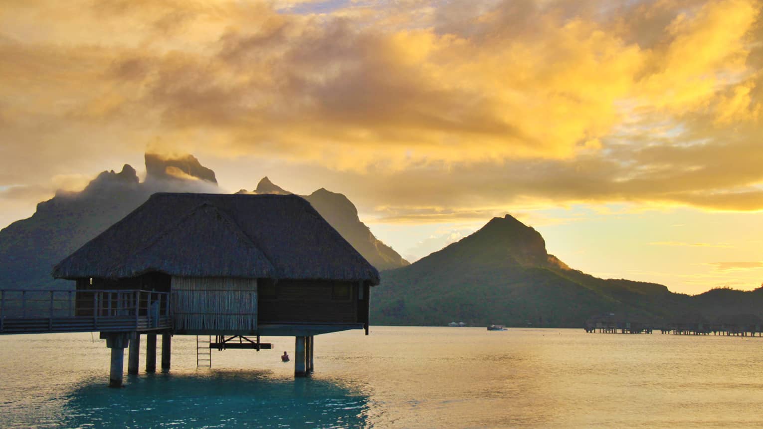 Overwater villa in tropical destination at sunset