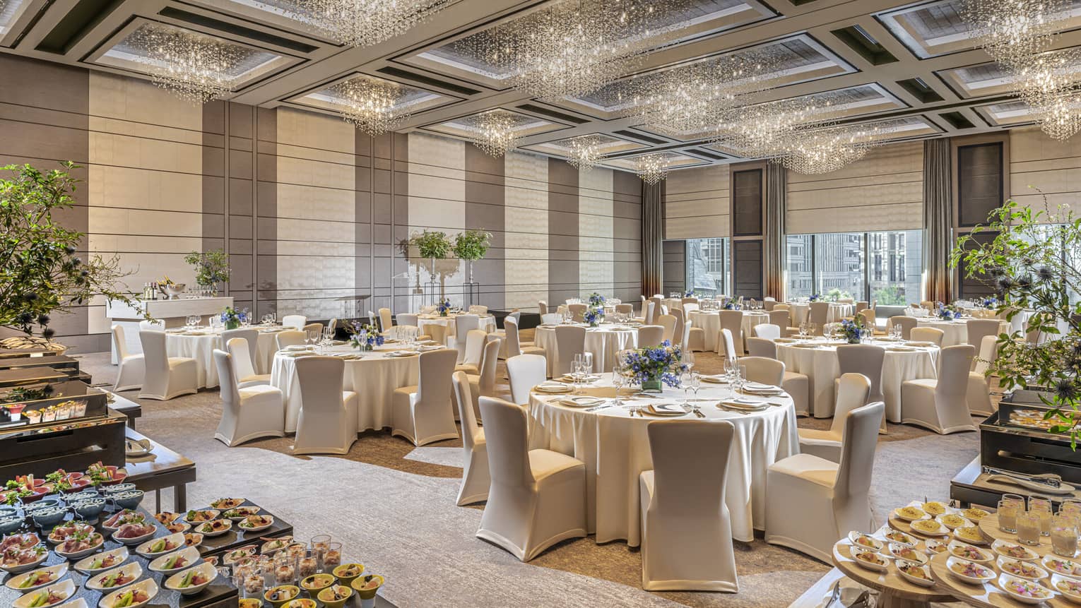 Grand Ballroom set up for a wedding with food, white linens and floral arrangements