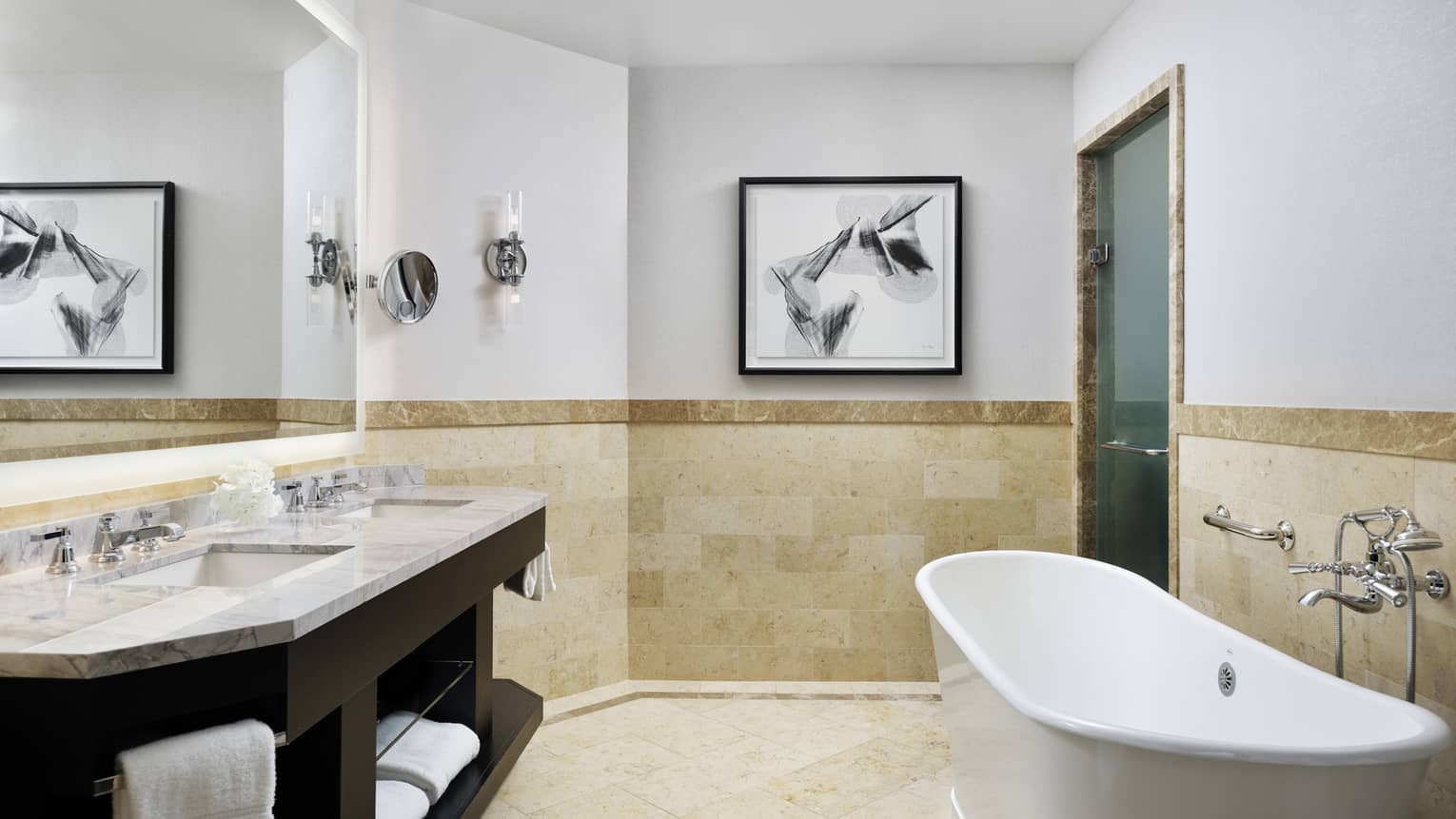 Double marbled vanity with two sinks, full-width mirror, large soaking tub, tiled wall at chair rail