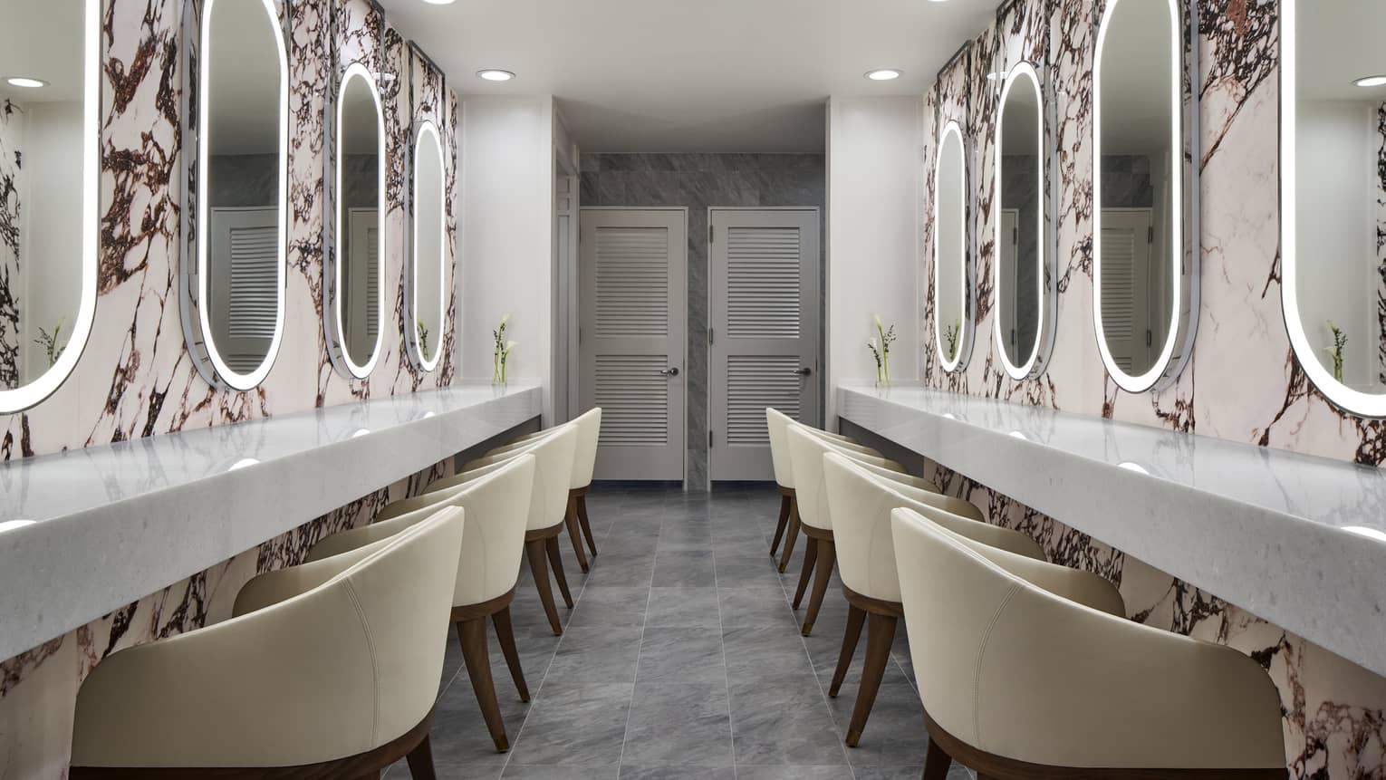 Modern luxury hotel spa with two walls of illuminated mirrors and chairs