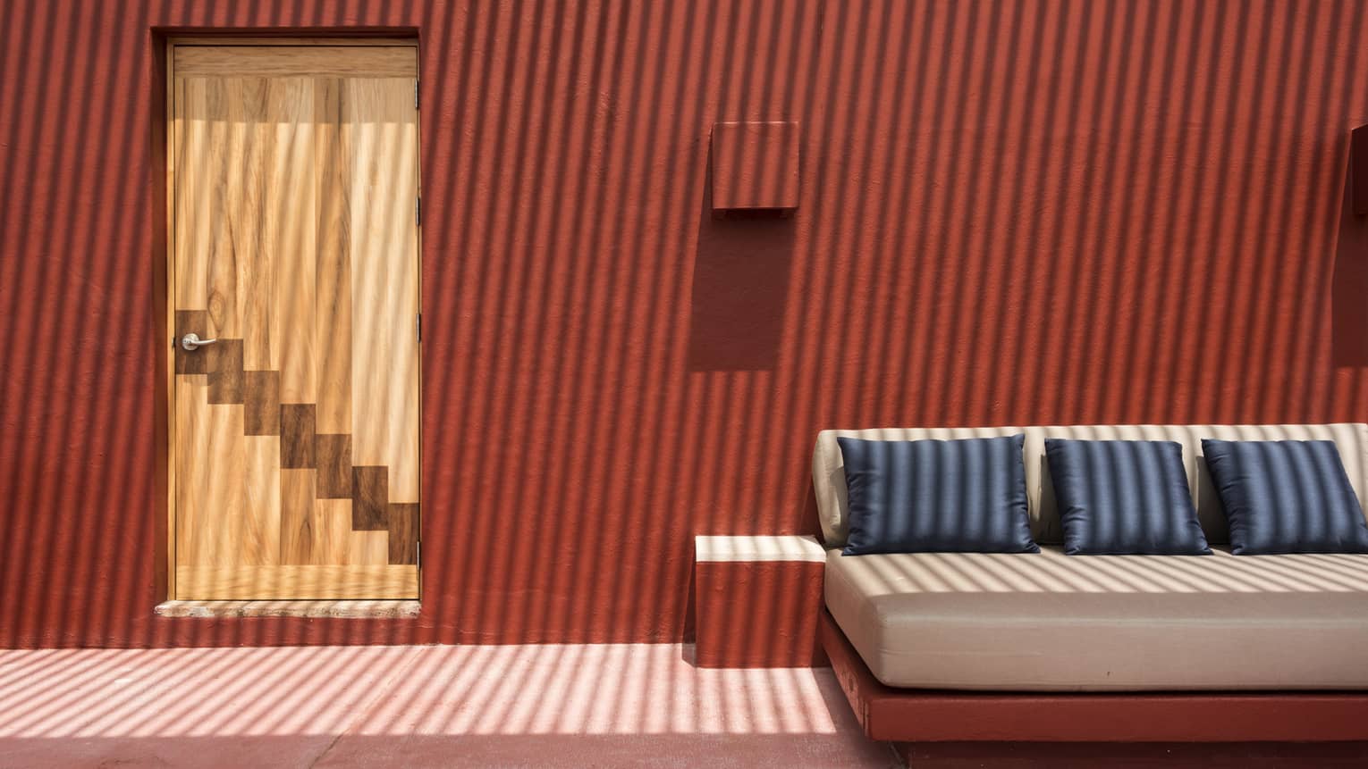 Contemporary sofa set against a red stucco wall