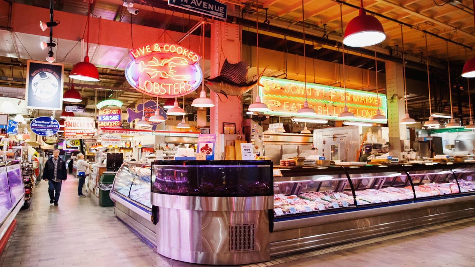 A large indoor market featuring fresh seafood behind glass windows.