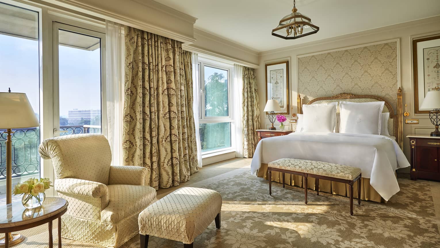 Diplomatic Suite with soft beige and cream decor, bed and club chair with ottoman