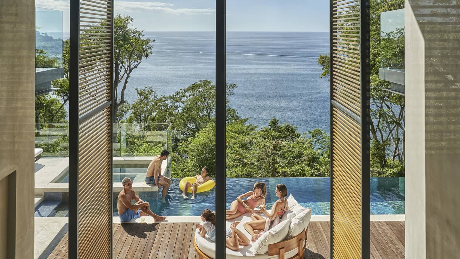 Family in private villa pool with ocean view