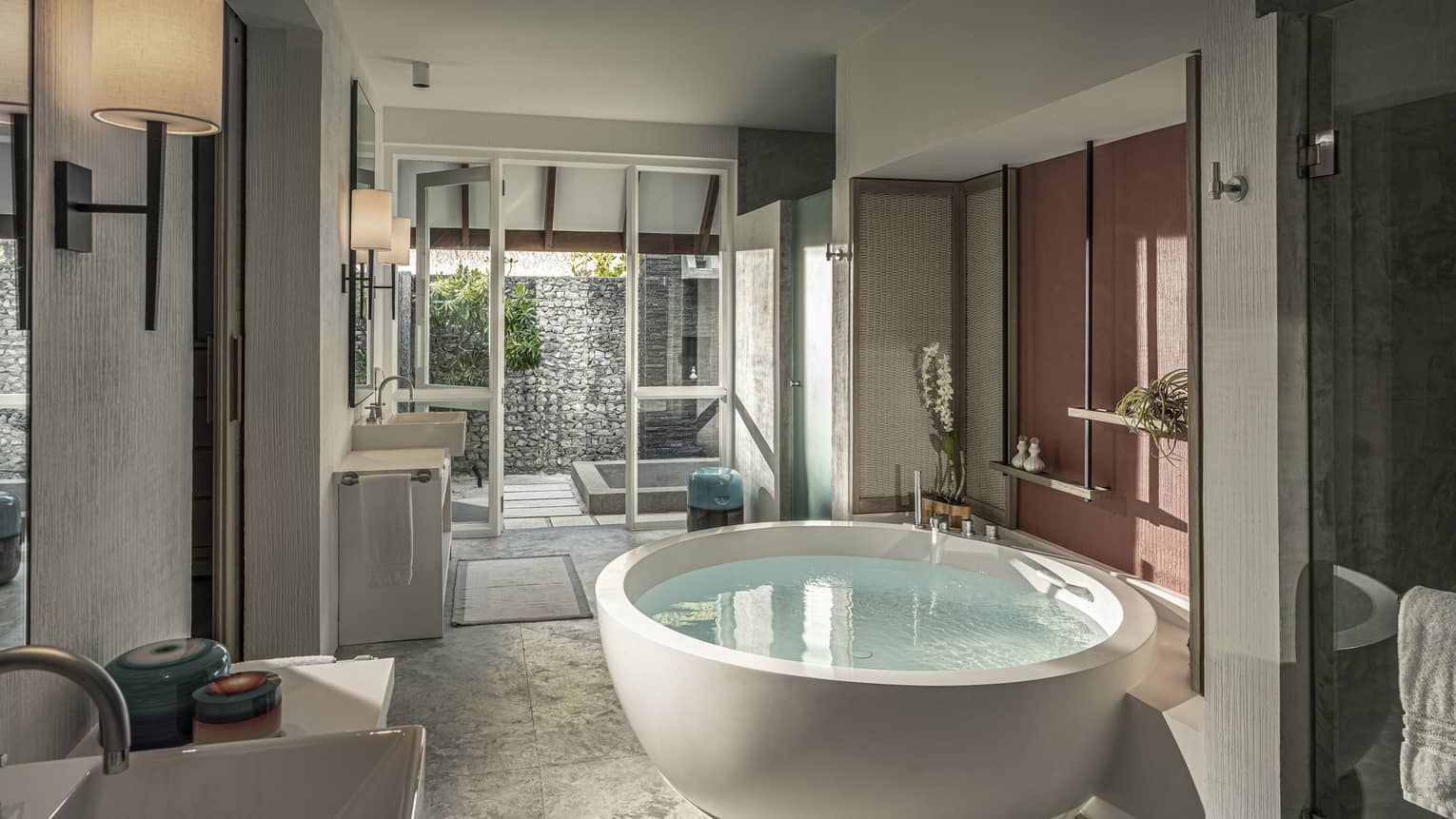Large bathroom with circular standalone tub, walk-out outdoor shower