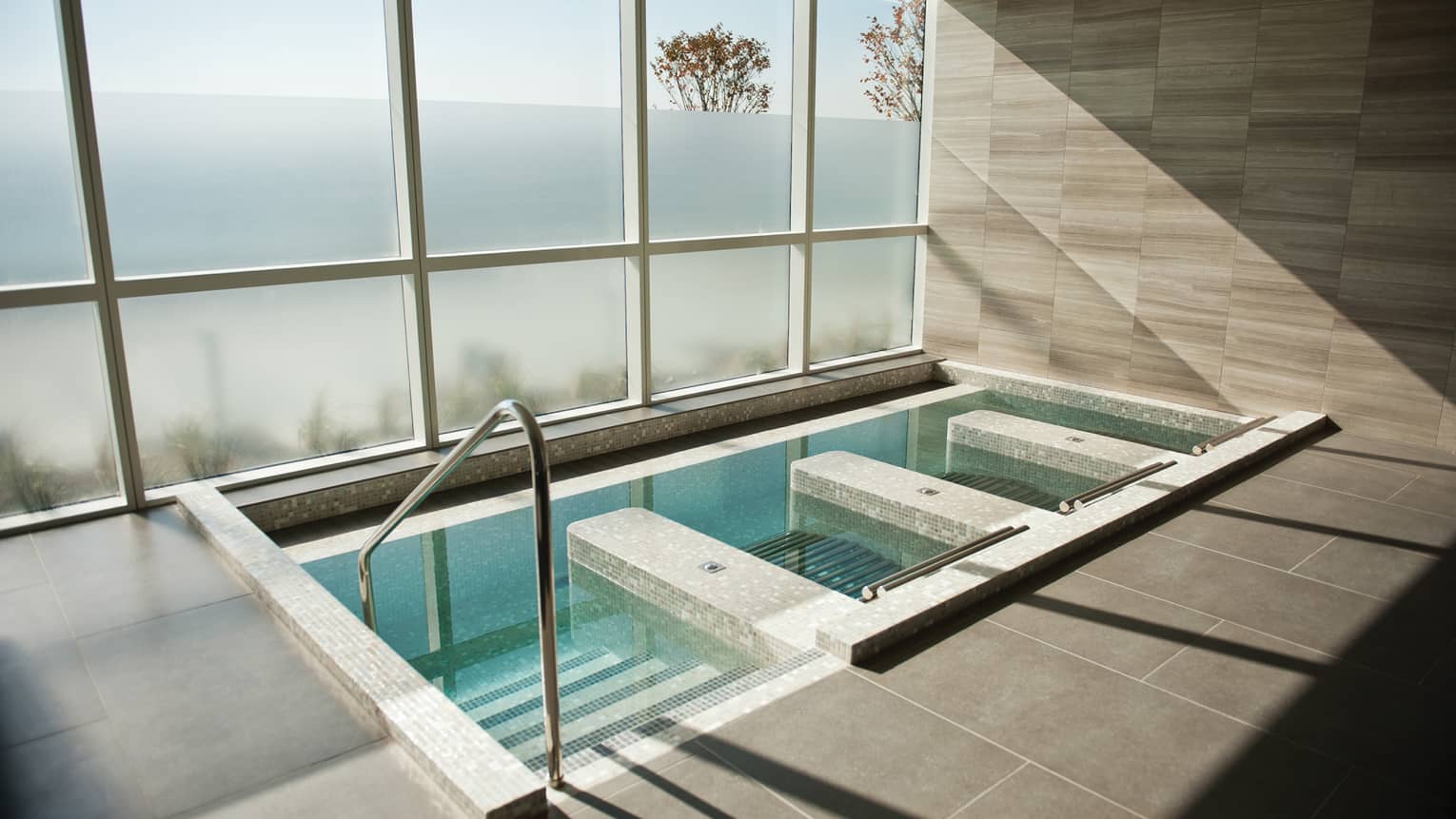 Steps down into tile spa plunge pool, tub under large window