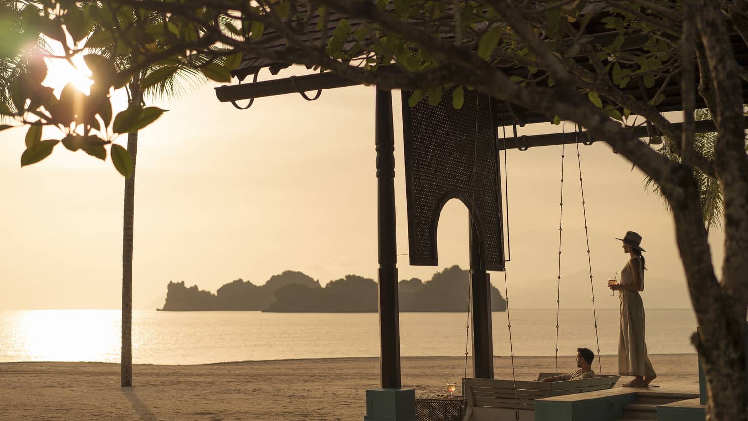 A woman overlooks the water on the beach at Rhu Bar