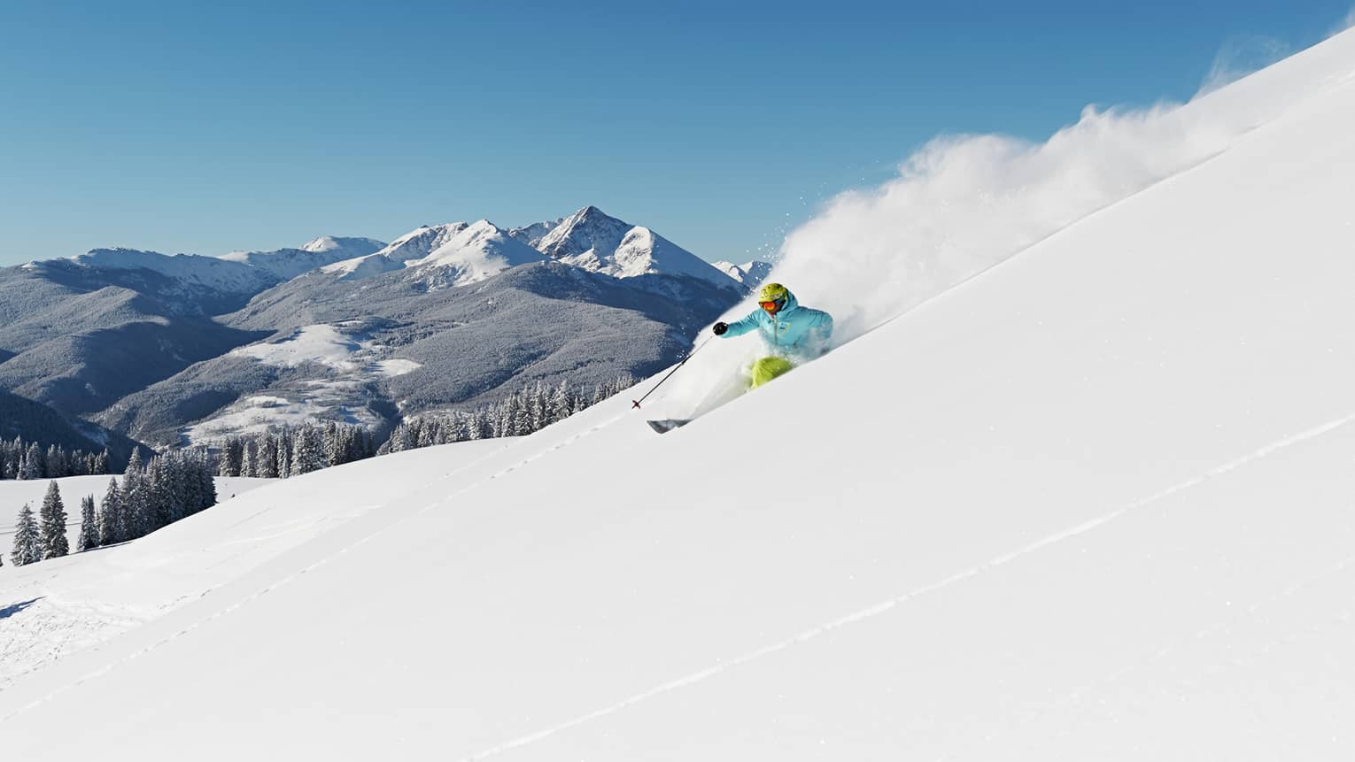 Person skiing down snow covered mountain top