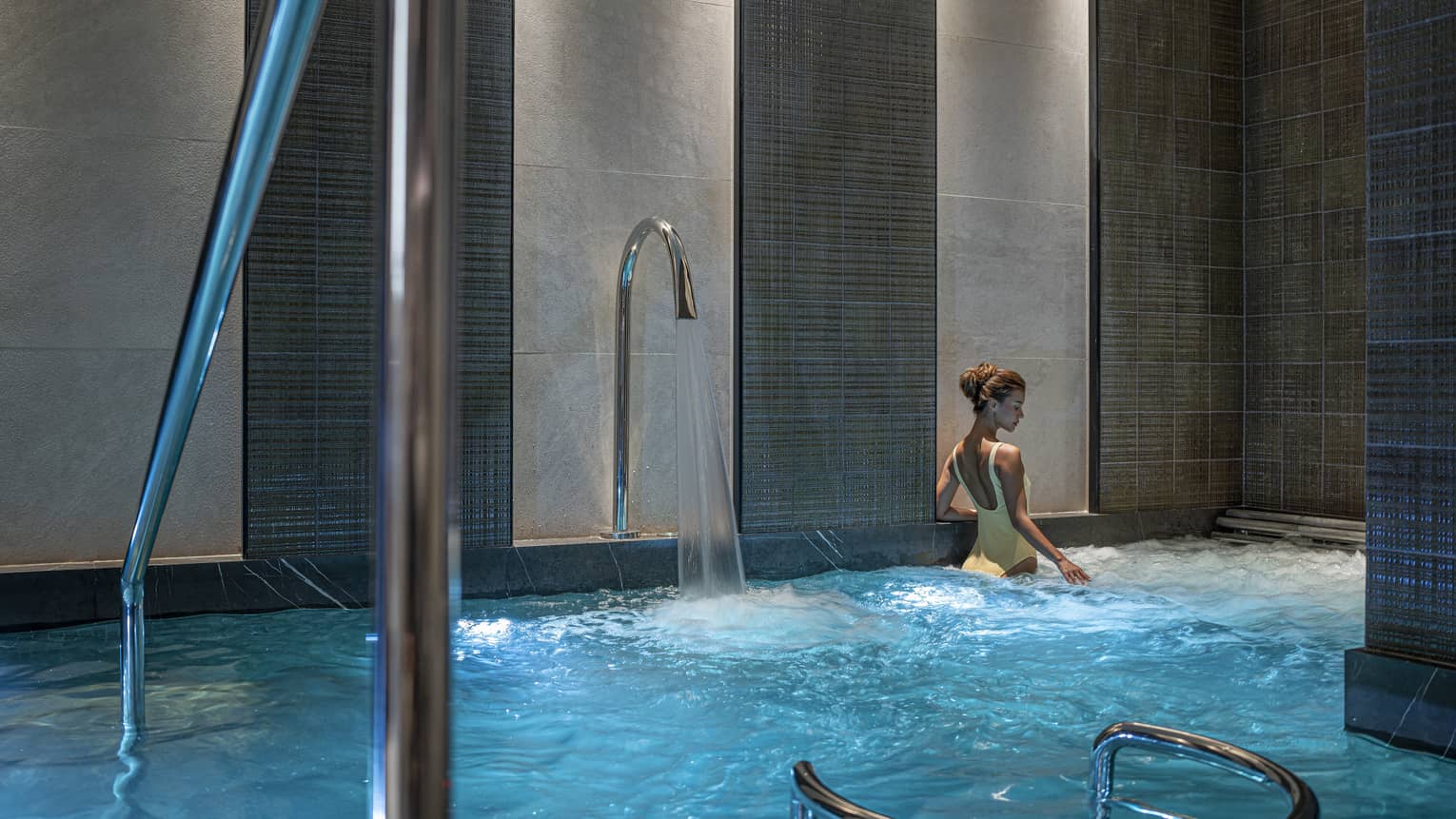 Woman in yellow bathing suit soaks in the Spa's vitality pool