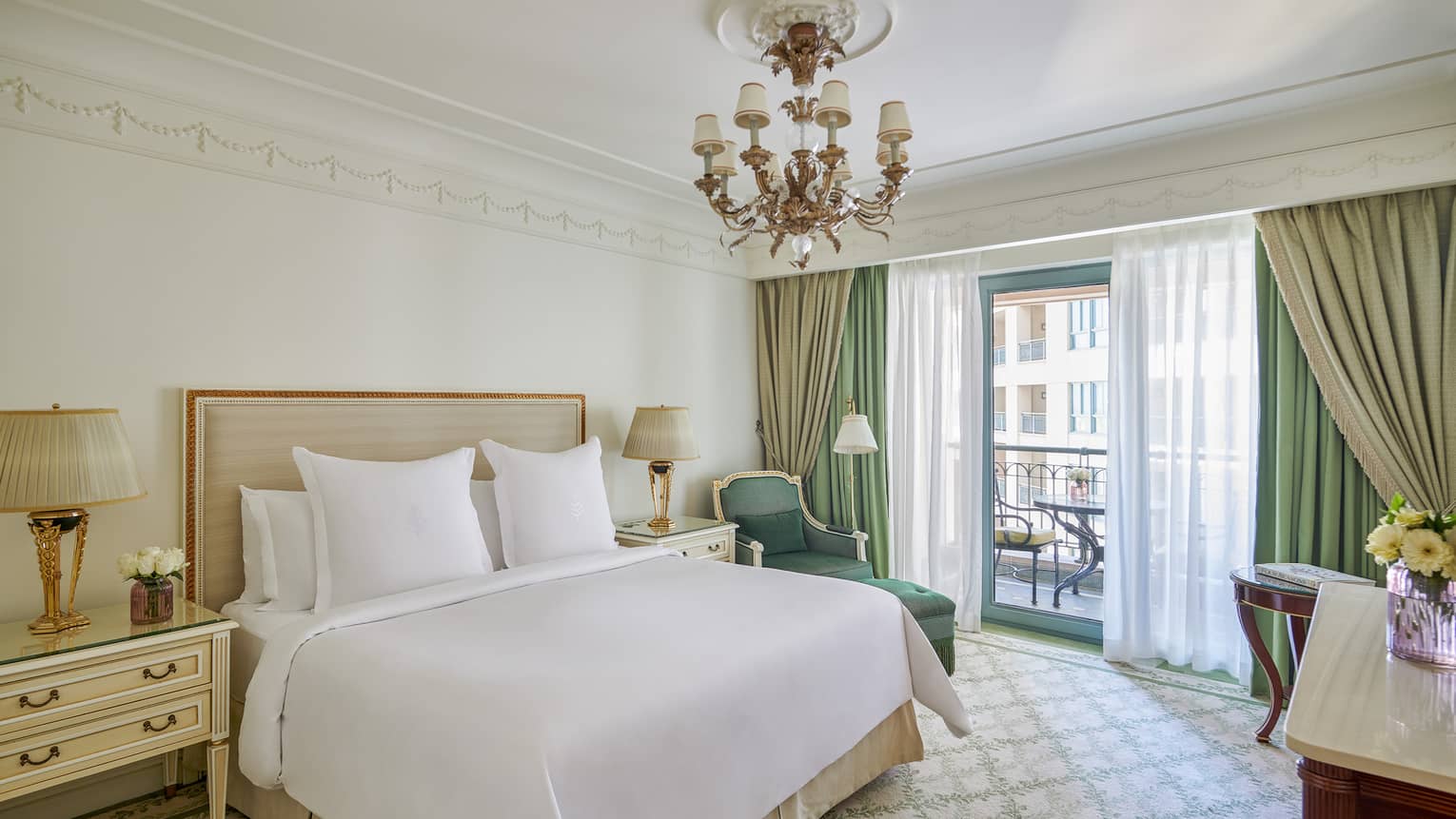 Four Seasons Suite bedroom with king bed, corner chaise longue, side table, glass door to veranda