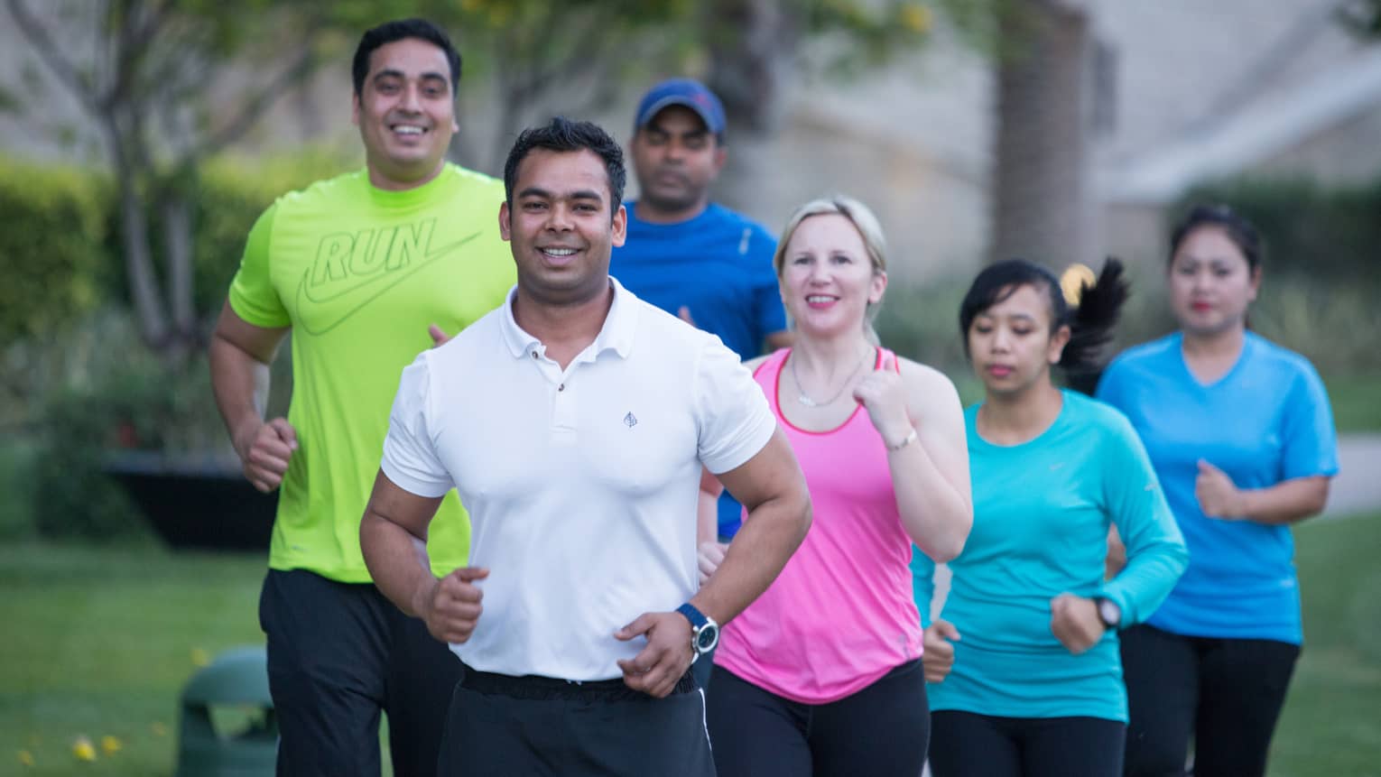 Group of six people wearing workout clothing, jogging