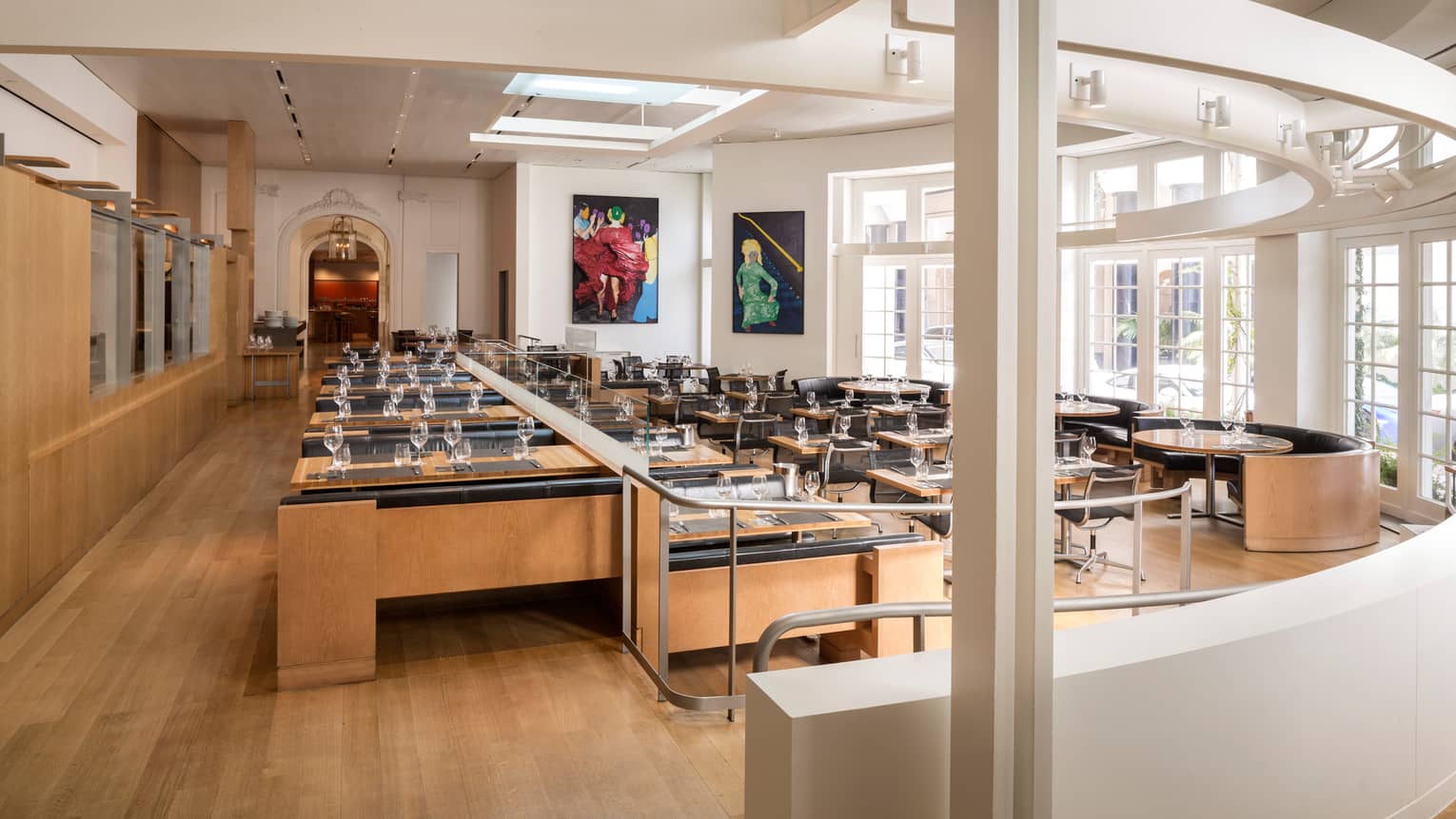 CUT restaurant bright dining room, rows of tables, curved white wall and window