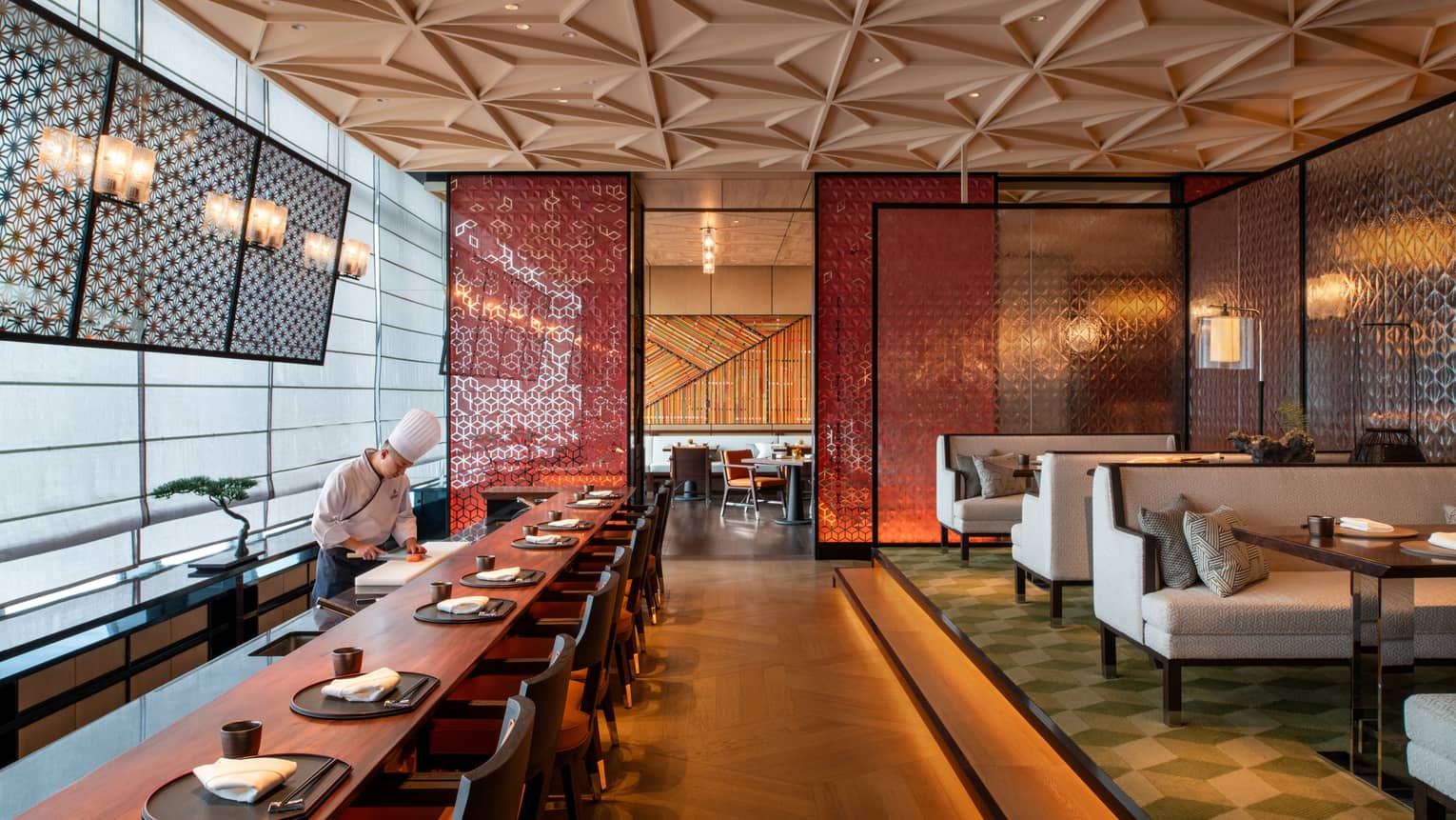 Chef prepares food at long dining bar at Yotsuba Japanese restaurant
