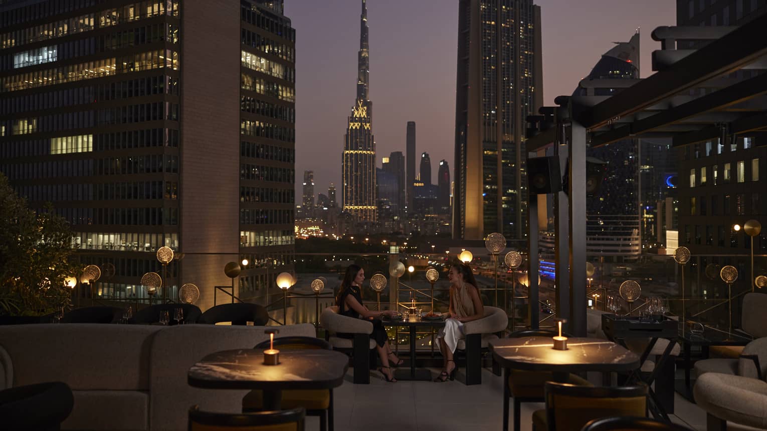 Nightime view of rooftop lounge with Dubai skyline in background