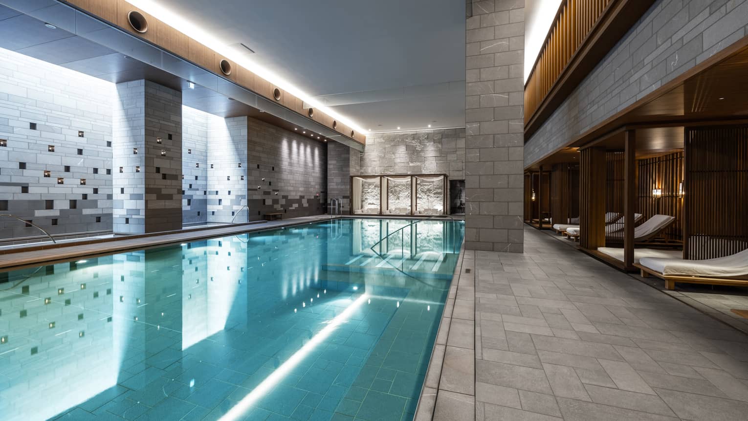 Indoor spa pool with chaise longues and grey columns