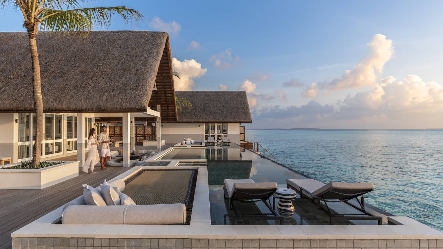 Couple walk out to large patio of Three Bedroom Water Suite