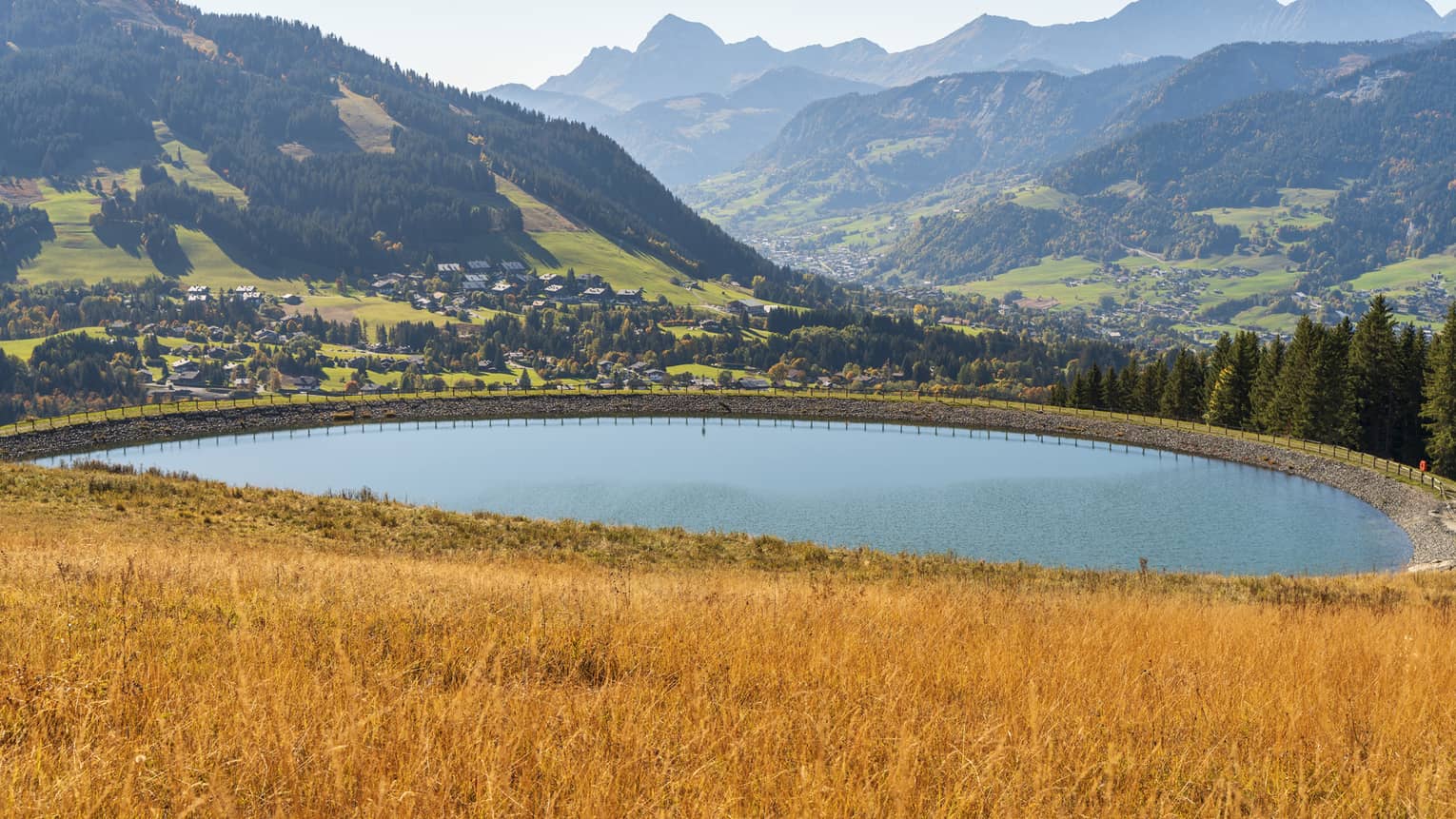 Oval lake at the foot of the Alps in autumn