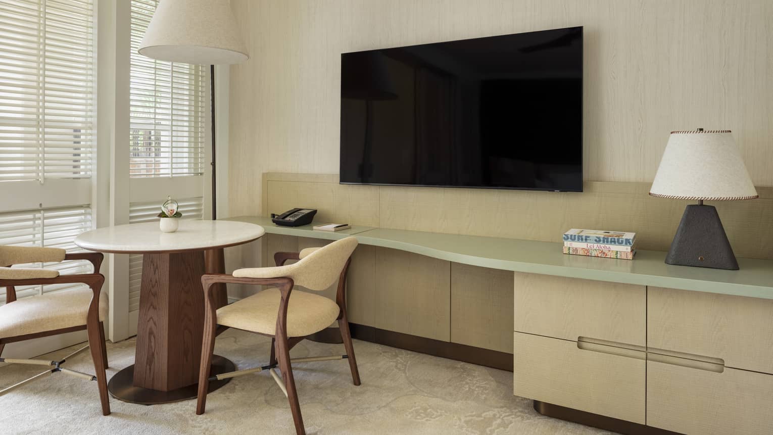 Contemporary resort room featuring a round table with two chairs by a TV
