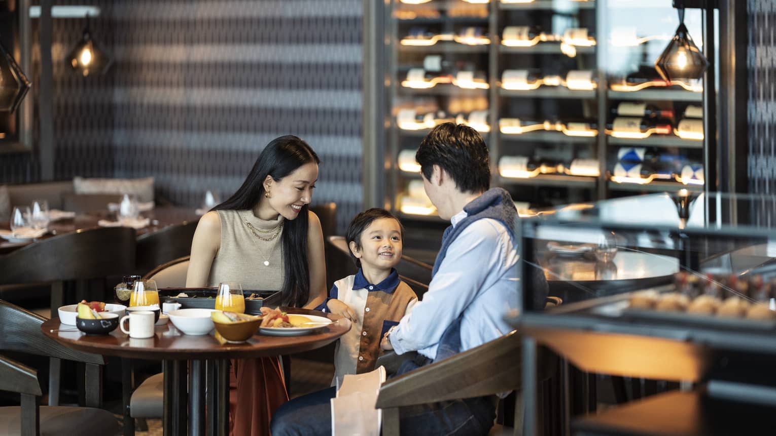 Parents and young boy enjoy a meal at PIGNETO