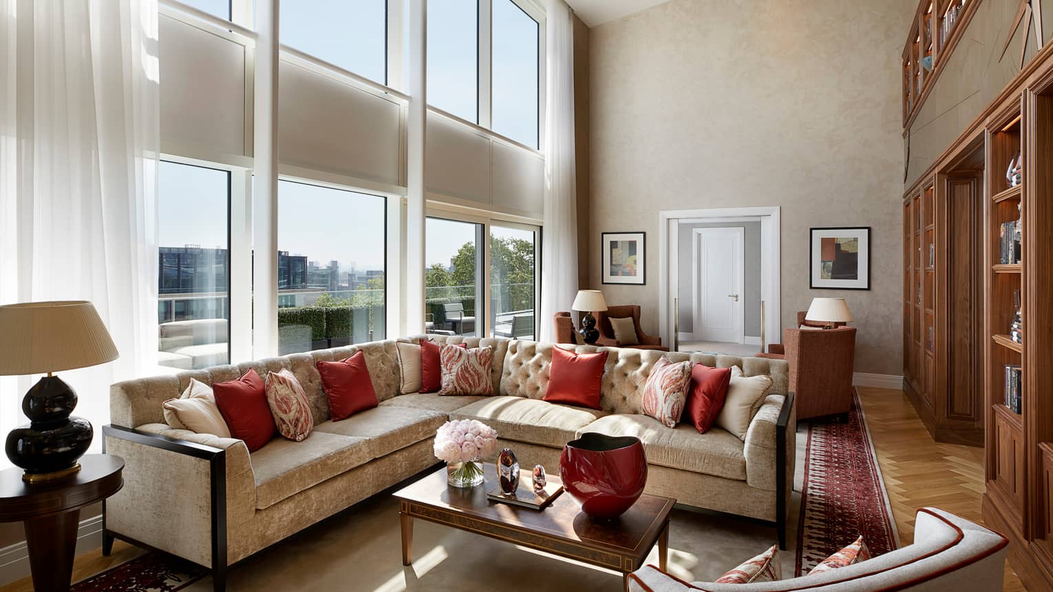 Large L-shaped velvet sofa, living room under sunny, two-storey floor-to-ceiling window