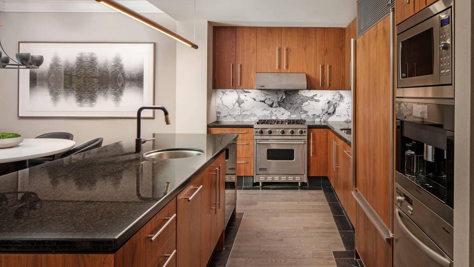 Kitchen with wooden cupboards and black granite countertops, stainless steel appliances