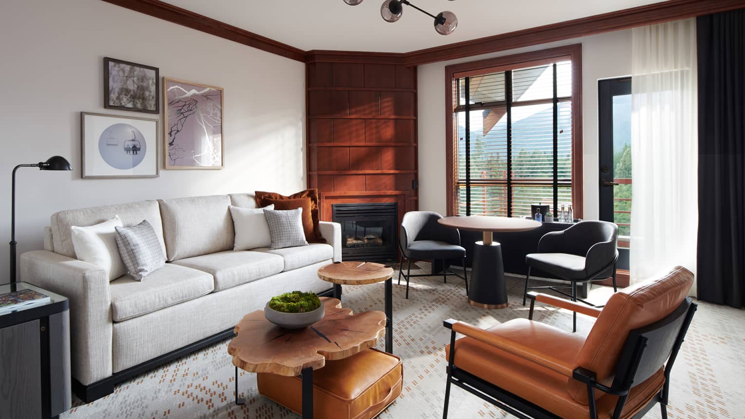 Chic and cozy Deluxe Suite at Four Seasons Whistler, showcasing a harmonious blend of contemporary and rustic elements. The living area is furnished with a sleek white sofa, tan leather chairs, a unique set of round wooden coffee tables, and a vintage-style leather suitcase used as a decorative piece. Wood-paneled walls and large windows offer views of the mountains, creating a luxurious yet inviting atmosphere. Artwork hangs above the sofa, adding a touch of elegance to the space.,Chic and cozy Deluxe Suite at Four Seasons Whistler, showcasing a harmonious blend of contemporary and rustic elements. The living area is furnished with a sleek white sofa, tan leather chairs, a unique set of round wooden coffee tables, and a vintage-style leather suitcase used as a decorative piece. Wood-paneled walls and large windows offer views of the mountains, creating a luxurious yet inviting atmosphere. Artwork hangs above the sofa, adding a touch of elegance to the space.
