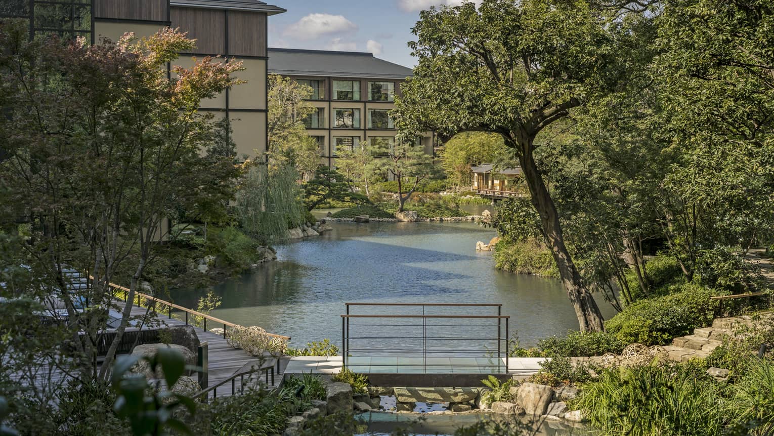 Trees, Shakusuien garden around pond under Four Seasons Hotel Kyoto building