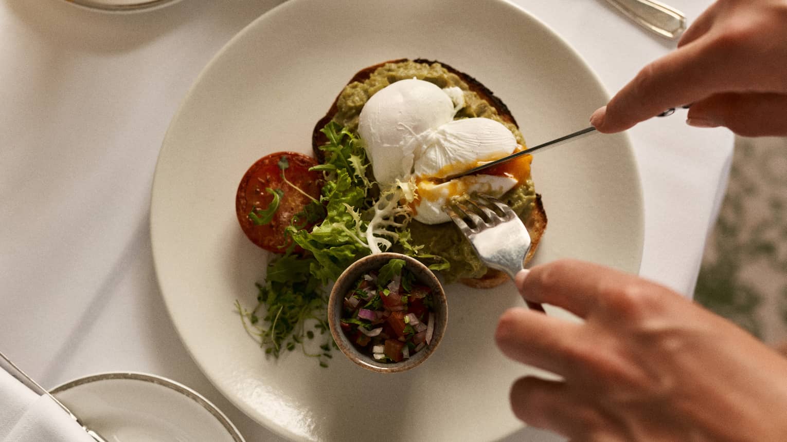 A person partakes of a plate of savoury food items.