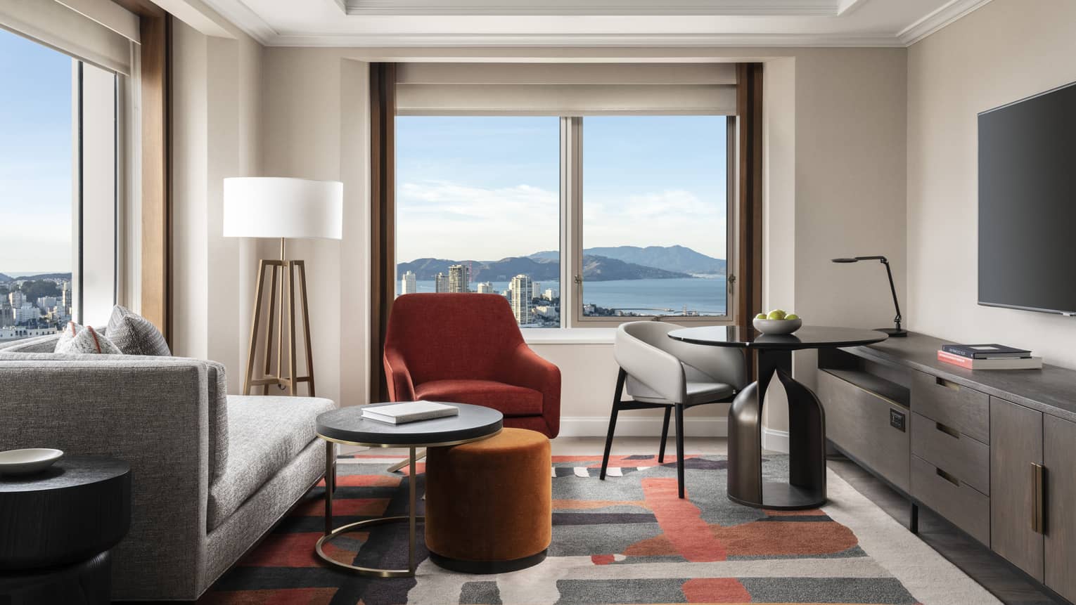 Living area in a hotel room, with corner views of San Francisco and bay