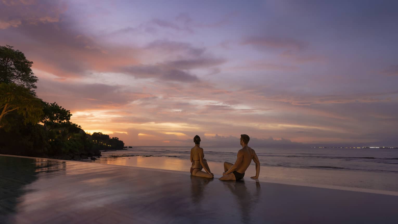 Couple watches the sunset at the infinity-edge pool at Sundara