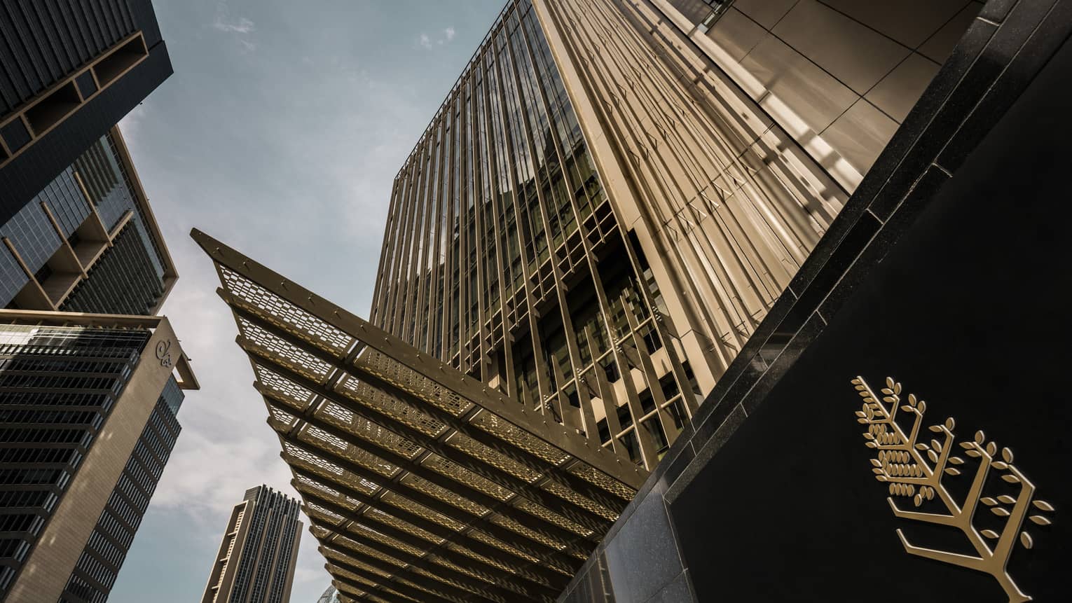 Looking up at high rise Dubai International Financial Centre hotel past gold Four Seasons logo