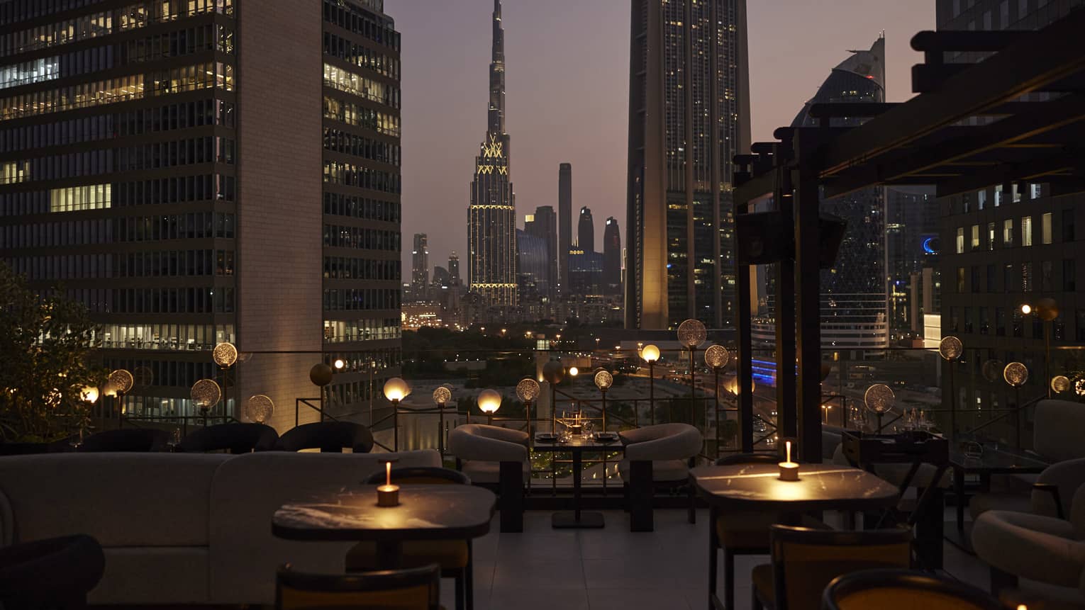 Nighttime patio view of Luna restaurant and city skyline in the background