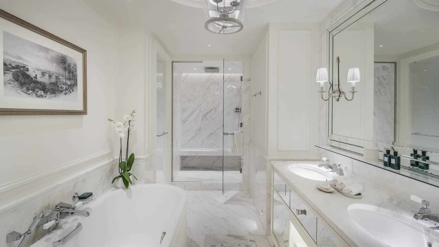 A marble bathroom with a large tub separate from a glass-walled shower.