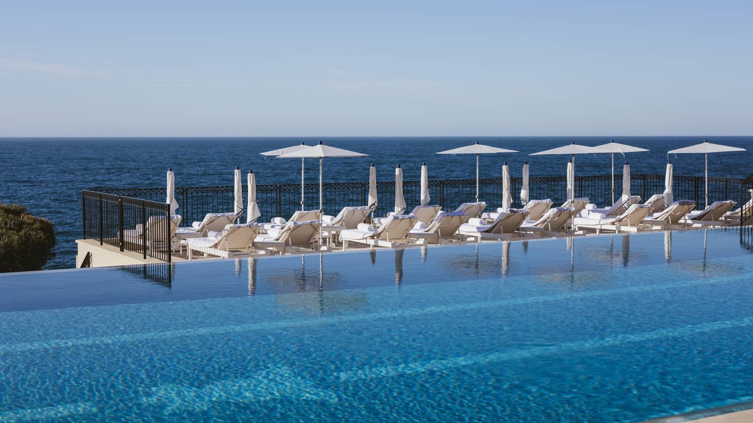 Sun loungers by infinity pool at luxury hotel