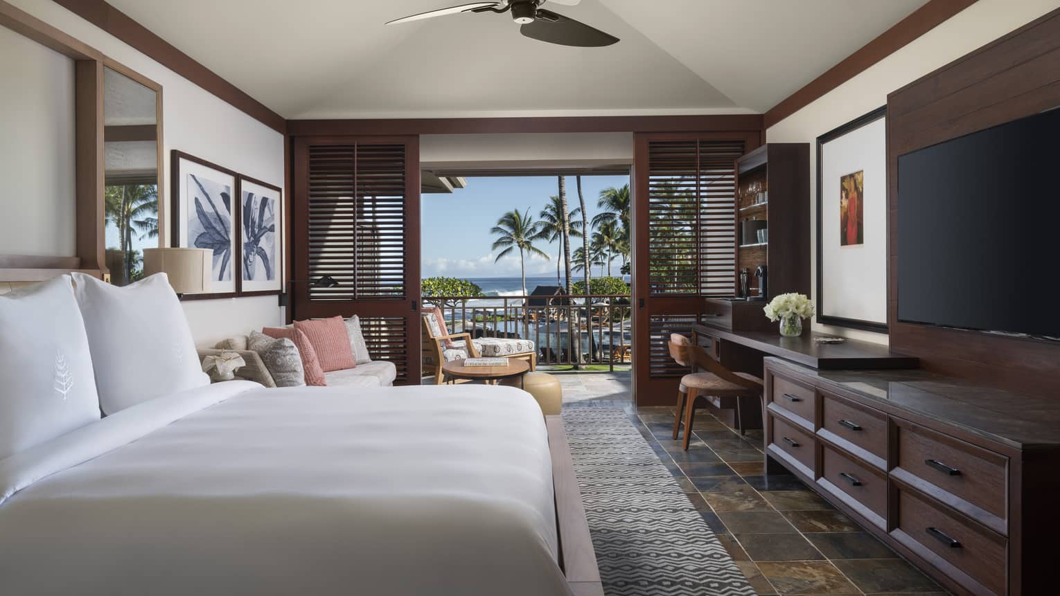 Bedroom with dark wood molding, ceiling fan, white king bed, dark dresser, walk-out terrace