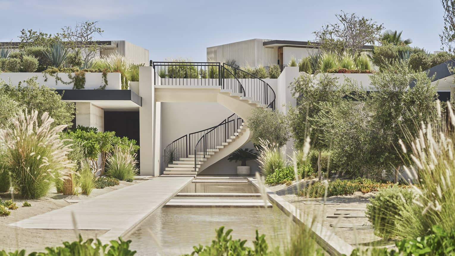 An outside courtyard with spiral stairs and plants.