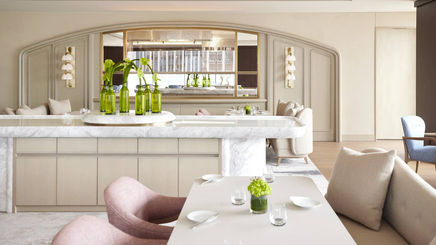 Sezanne dining room with soft beige and desert rose colours, natural light, large marble island, greenery throughout