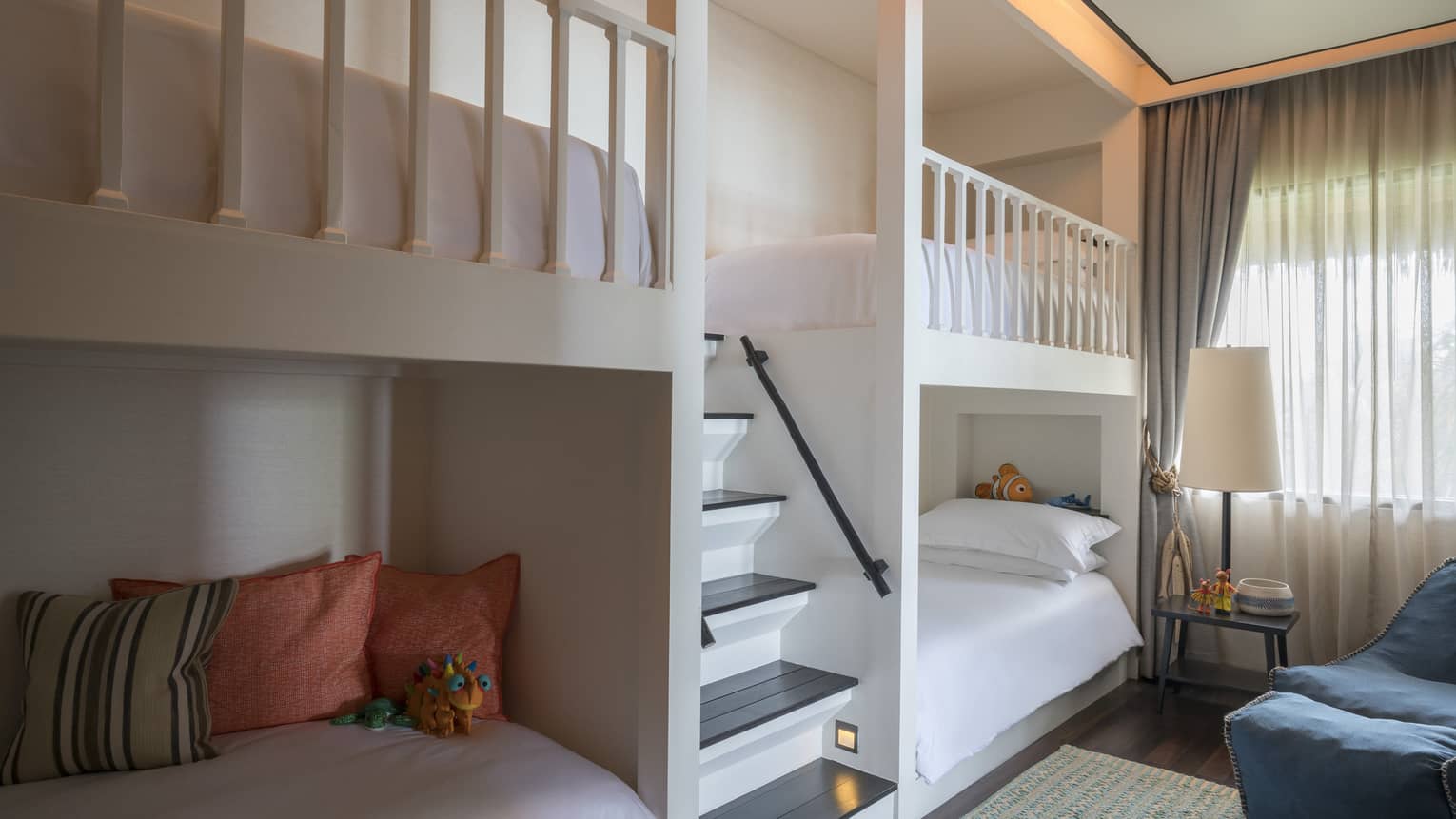 Bunk beds, pillows on either side of small staircase in children's room