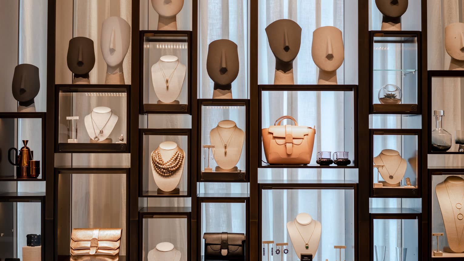 Wooden and glass display case with merchandise like jewelry and handbags