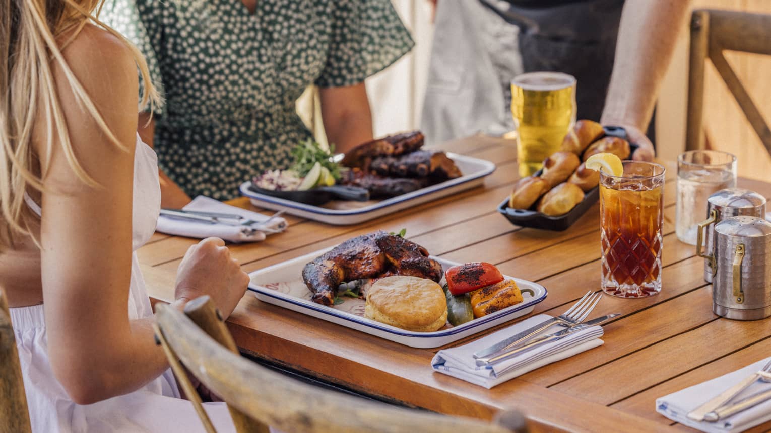 Two women dine at table with barbecue