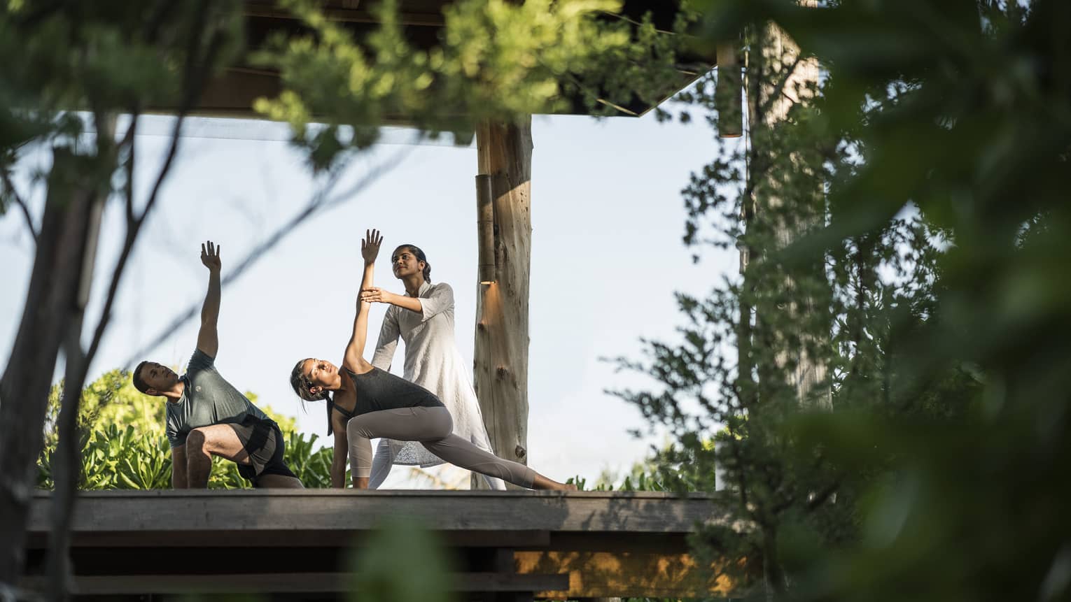 Couple stretching during outdoor yoga class