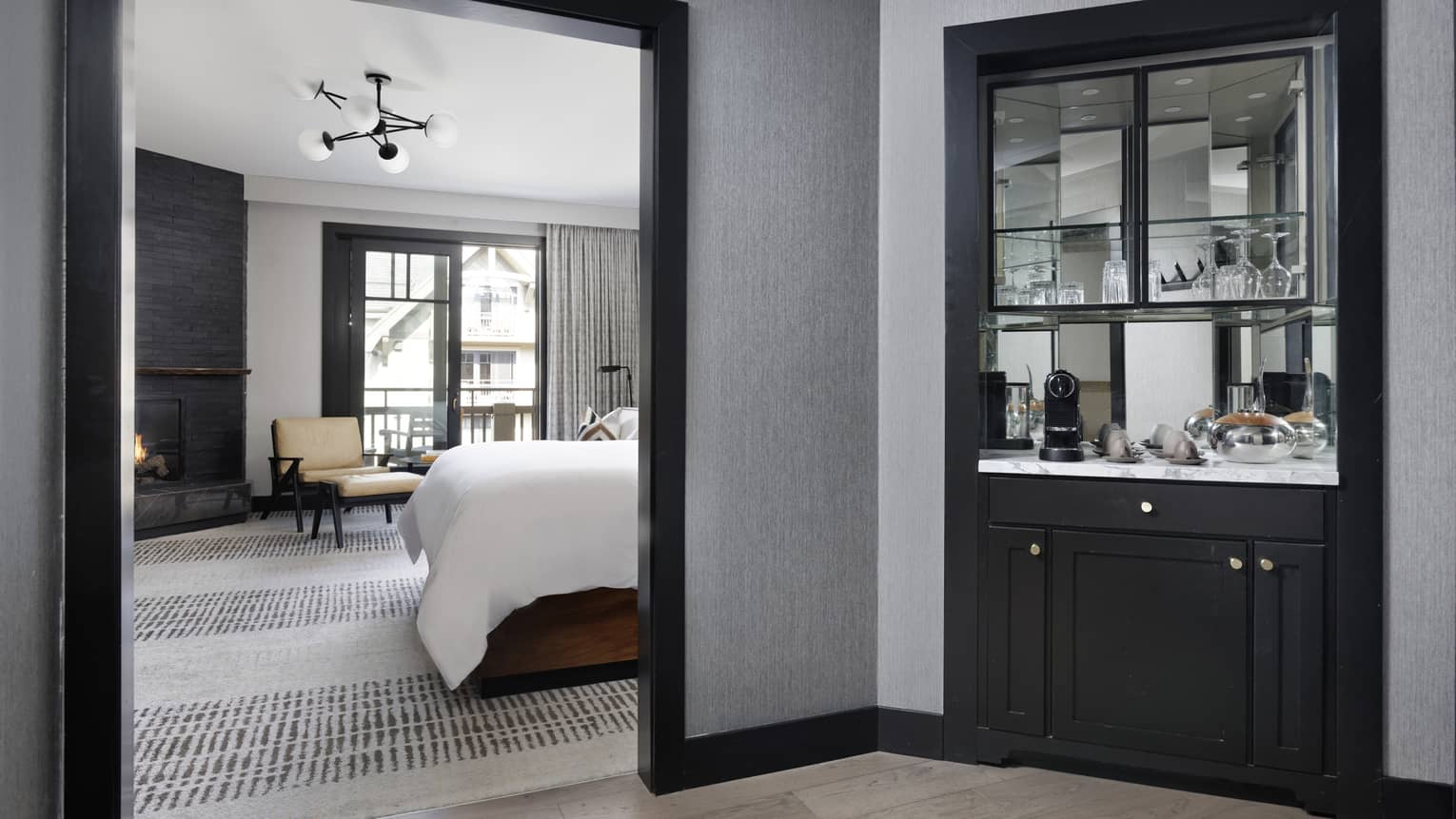 Mirrored snack bar, bedroom with bed and chaise lounge visible through doorway