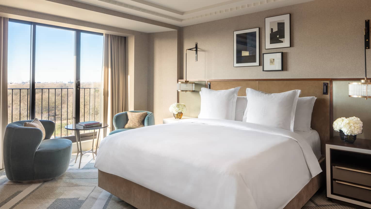 Elegant and cozy premier park view room at the Four Seasons London Park Lane in Mayfair. The room features a large king-sized bed with pristine white bedding and multiple pillows. Modern furnishings include a dark blue armchair, a small round table with two chairs, and stylish lamps. Large windows offer a splendid view of the park outside, filling the room with natural light. The decor is complemented by neutral tones, subtle art pieces on the walls, and a sophisticated ambiance,Elegant and cosy Premier Park-View Room at Four Seasons London Park Lane in Mayfair. The room features a large king-sized bed with pristine white bedding and multiple pillows. Modern furnishings include a dark blue armchair, a small round table with two chairs, and stylish lamps. Large windows offer a splendid view of the park outside, filling the room with natural light. The decor is complemented by neutral tones, subtle art pieces on the walls, and a sophisticated ambiance,Elegant and cosy Premier Park-View Room at Four Seasons London Park Lane in Mayfair. The room features a large king-sized bed with pristine white bedding and multiple pillows. Modern furnishings include a dark blue armchair, a small round table with two chairs, and stylish lamps. Large windows offer a splendid view of the park outside, filling the room with natural light. The decor is complemented by neutral tones, subtle art pieces on the walls, and a sophisticated ambiance