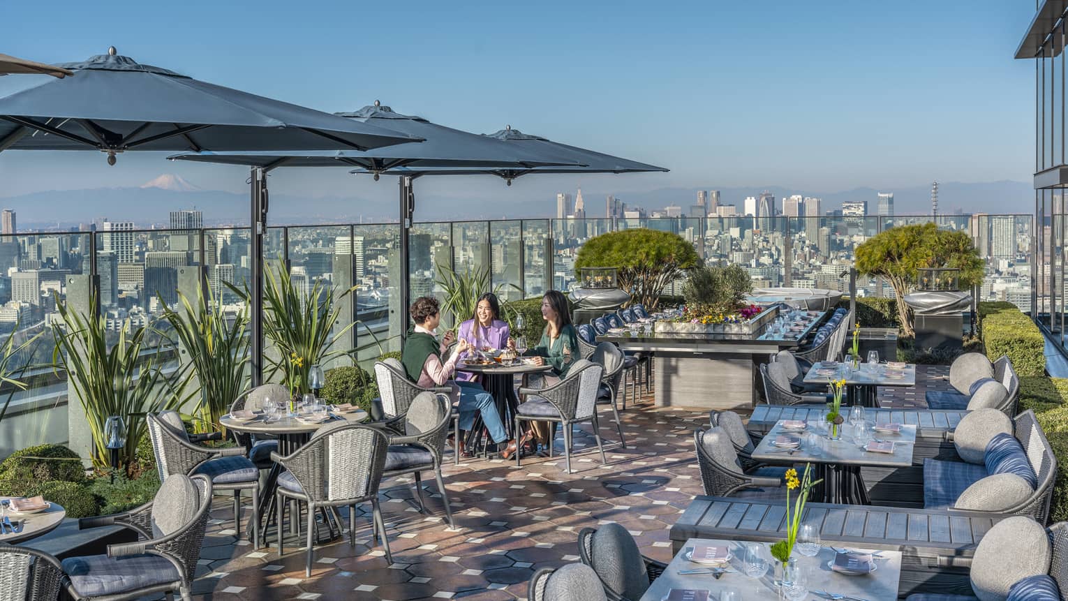 Group of three friends enjoy a meal on PIGNETO's open-air terrace