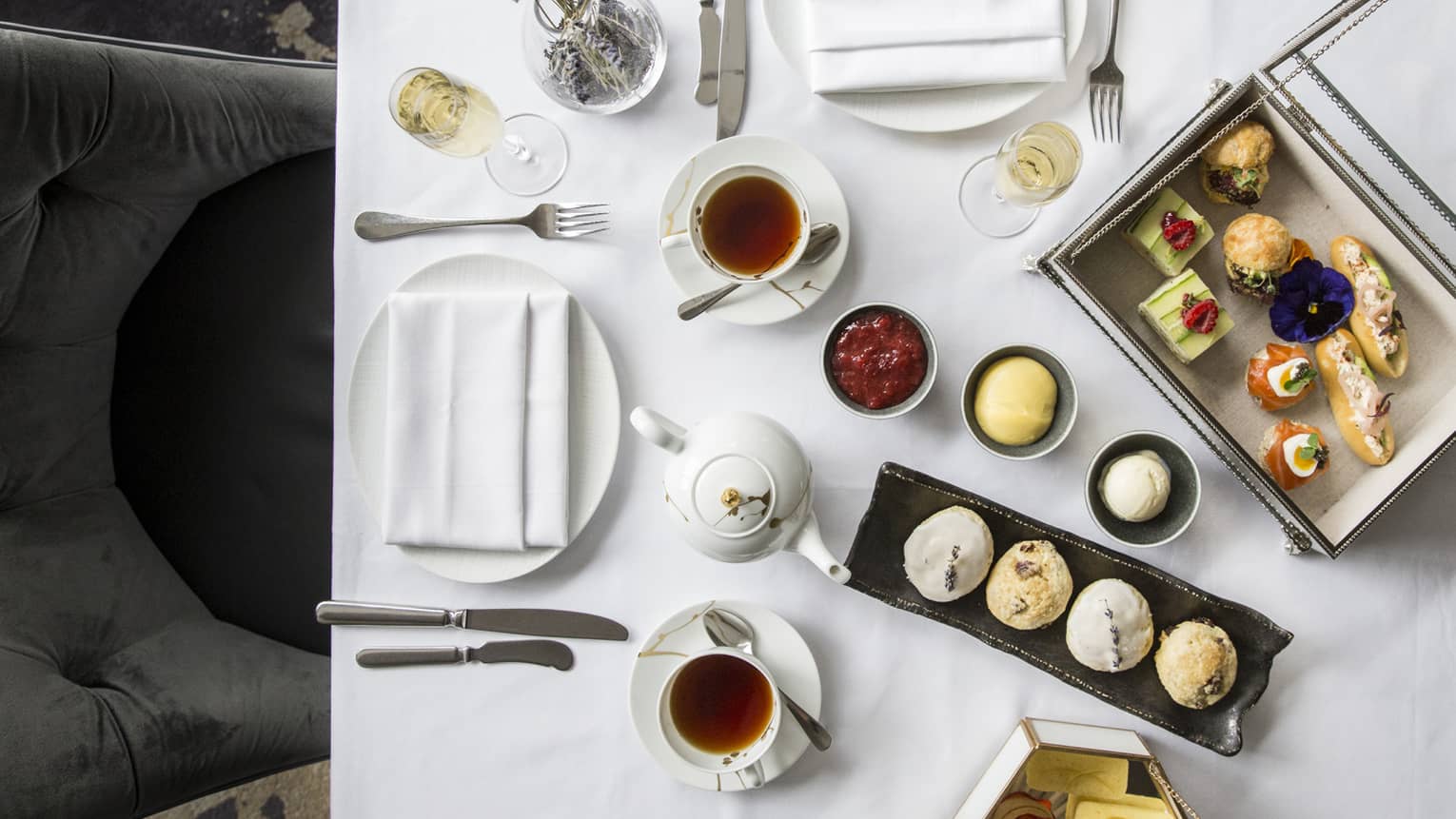 Aerial view of elegant afternoon tea display, complete with finger foods and condiments