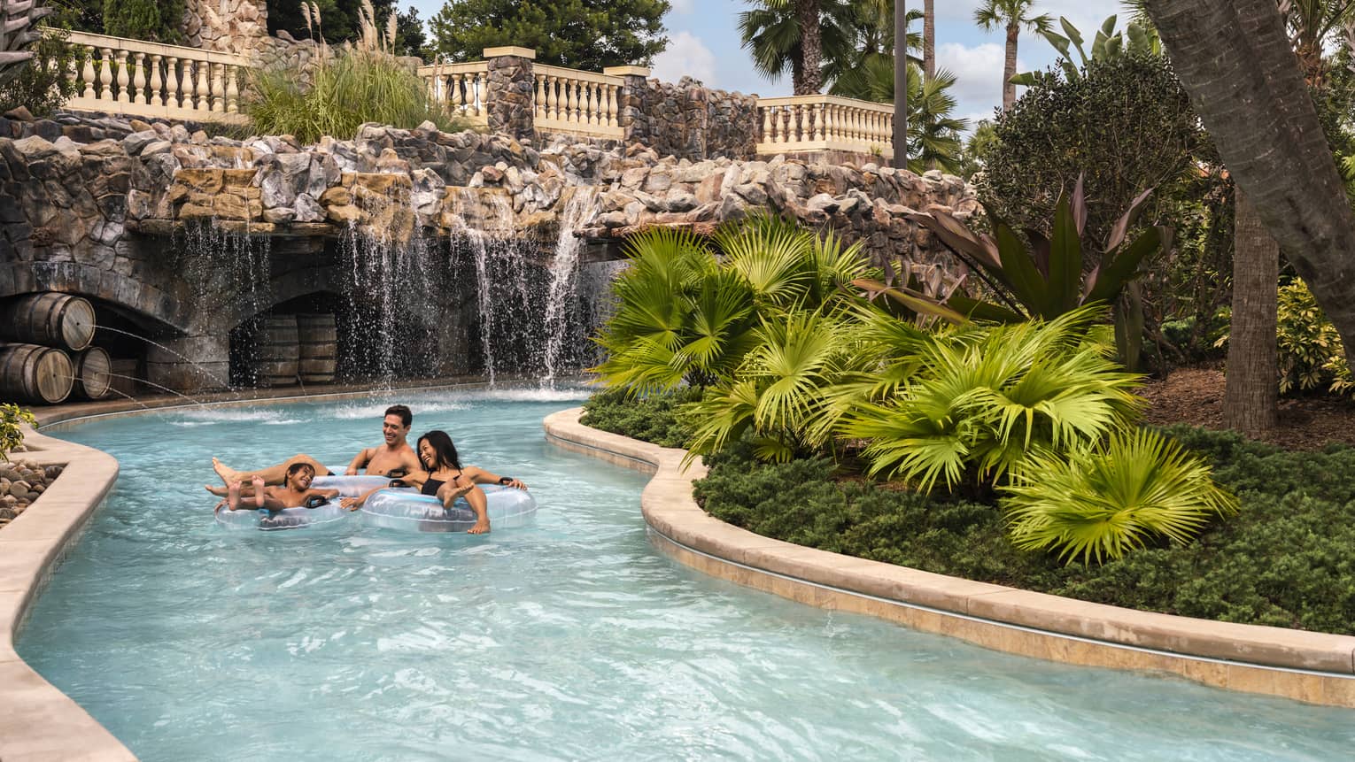 Two adults and a child ride in light-blue inner tubes along the Resort's outdoor lazy river